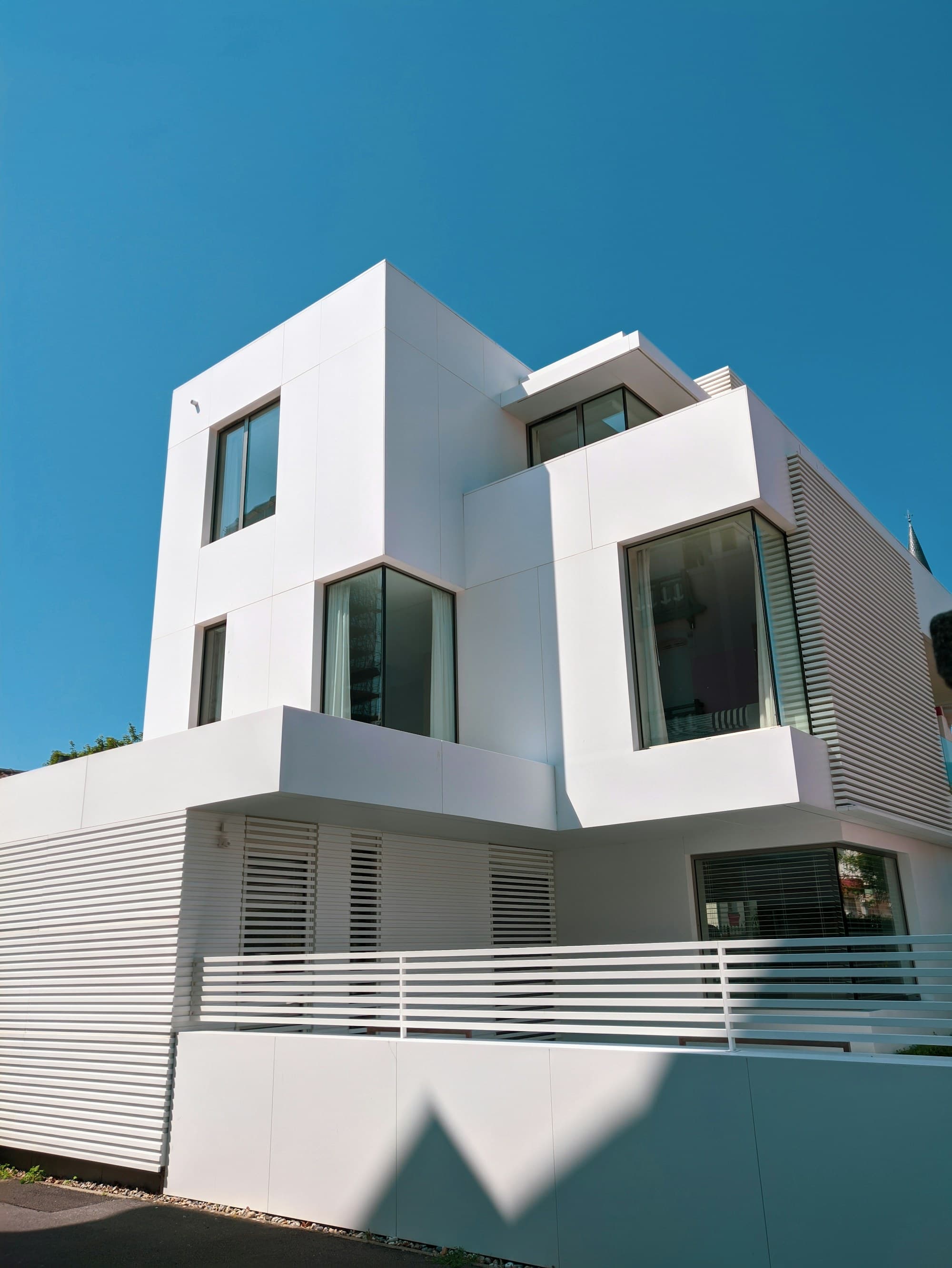 Maison contemporaine blanche à toit plat au Touquet-Paris-Plage, sous un ciel bleu